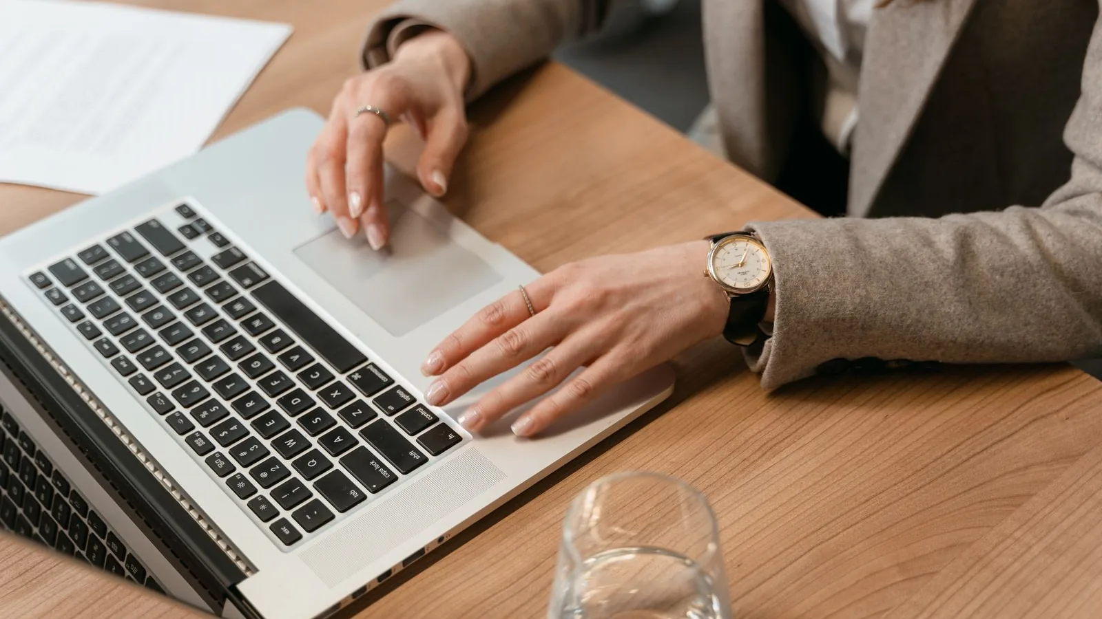 Personne travaillant sur un ordinateur portable, documents à côté