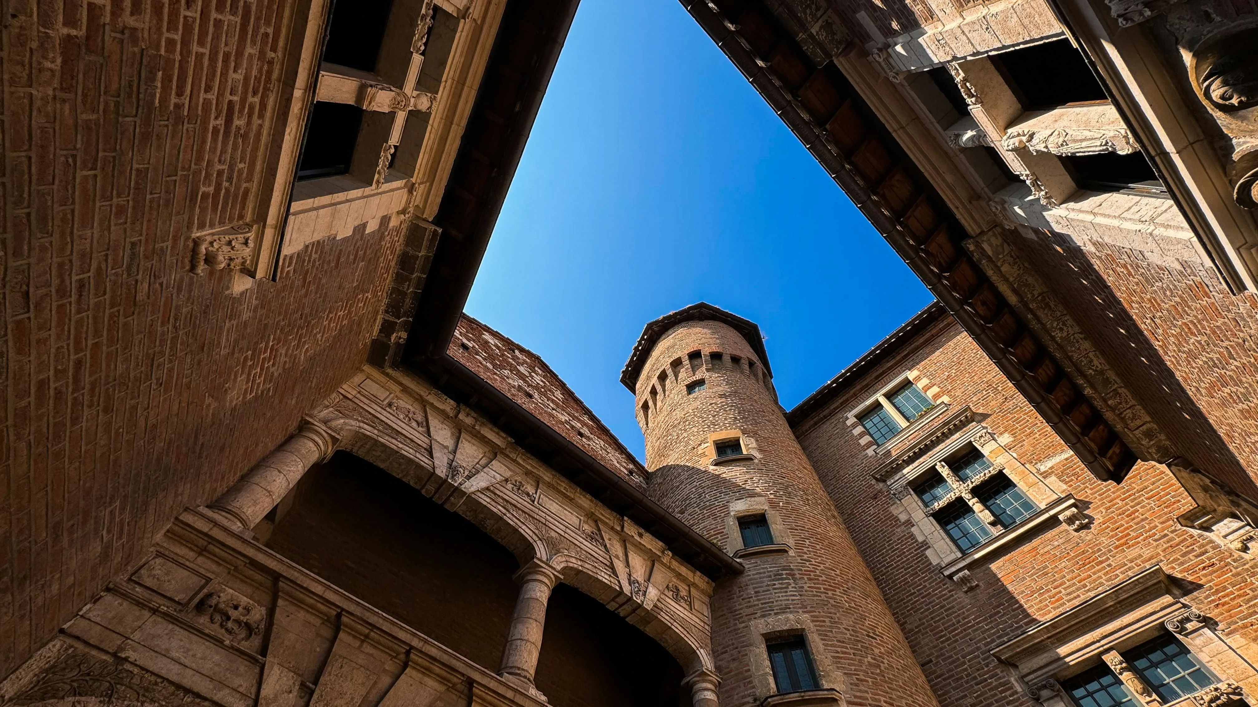 Cour intérieure d'un bâtiment historique d'Albi en briques rouges avec tour ronde et arches