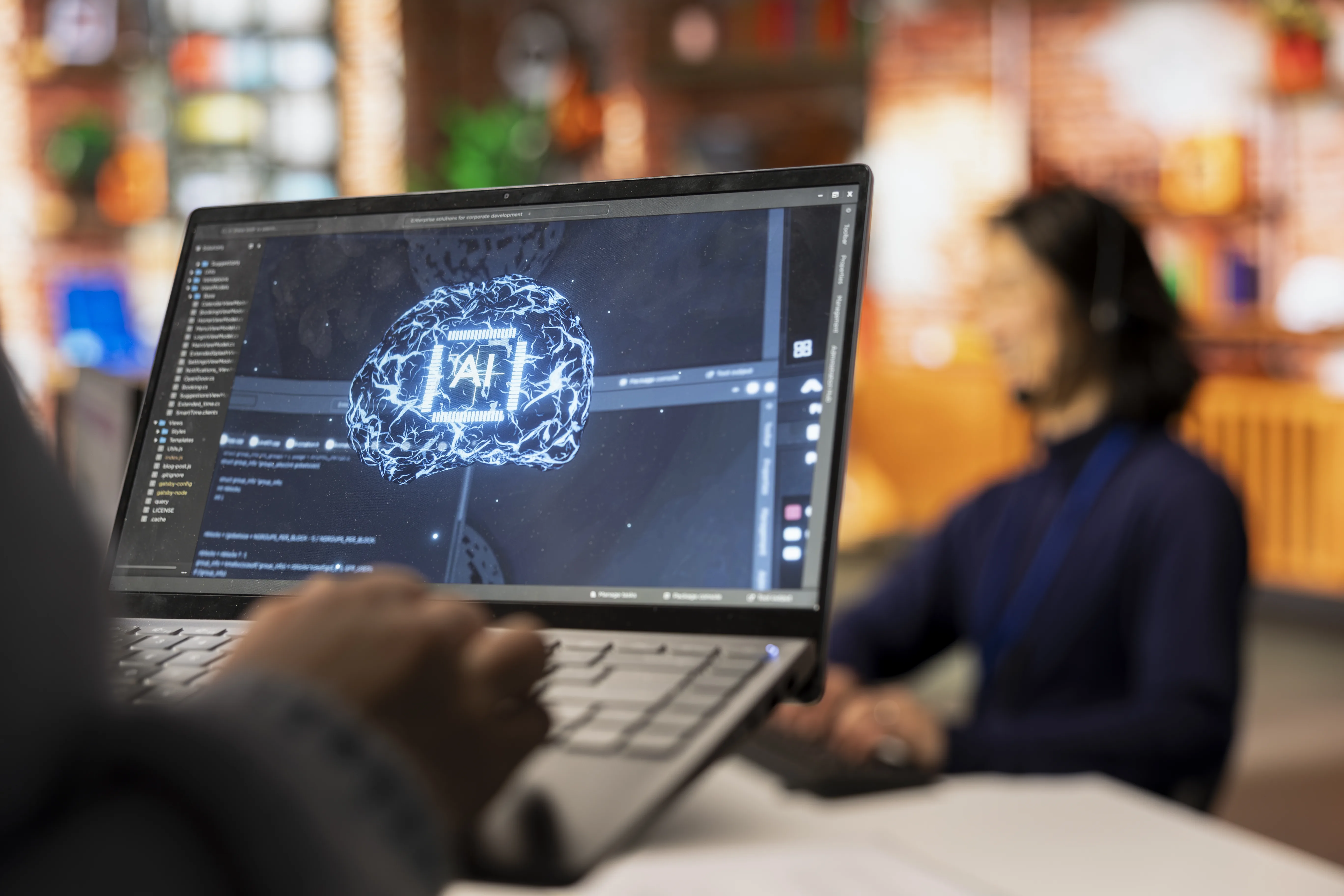 Développeur intégrant un agent IA dans une application métier, écran affichant un cerveau IA et du code source